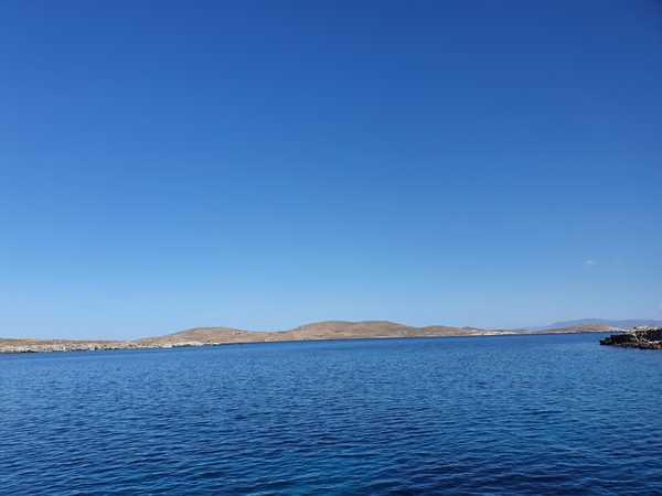 The low hills of Rhenia island seen across the water from an approaching boat