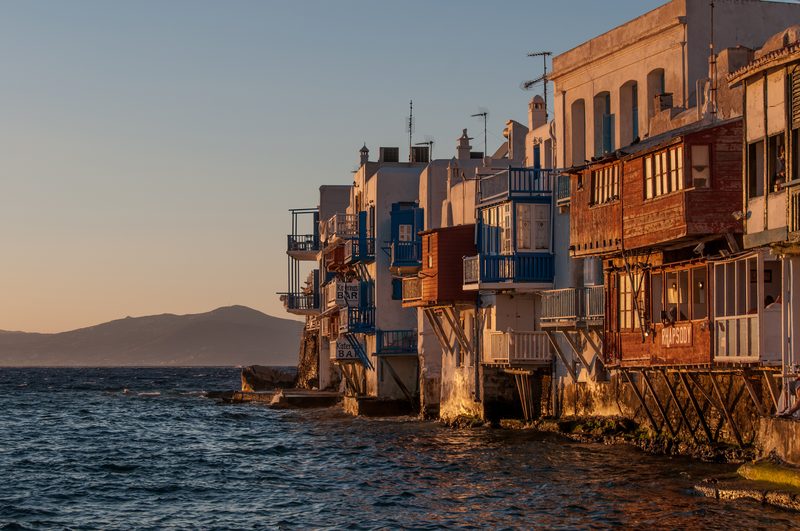 A vibrant sunset over the picturesque coastline of Mykonos, Greece.