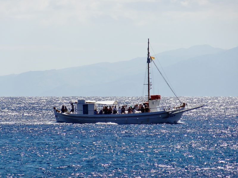 A boat tour vessel cruising in Tsangari Bay on the Greek island of Mykonos.