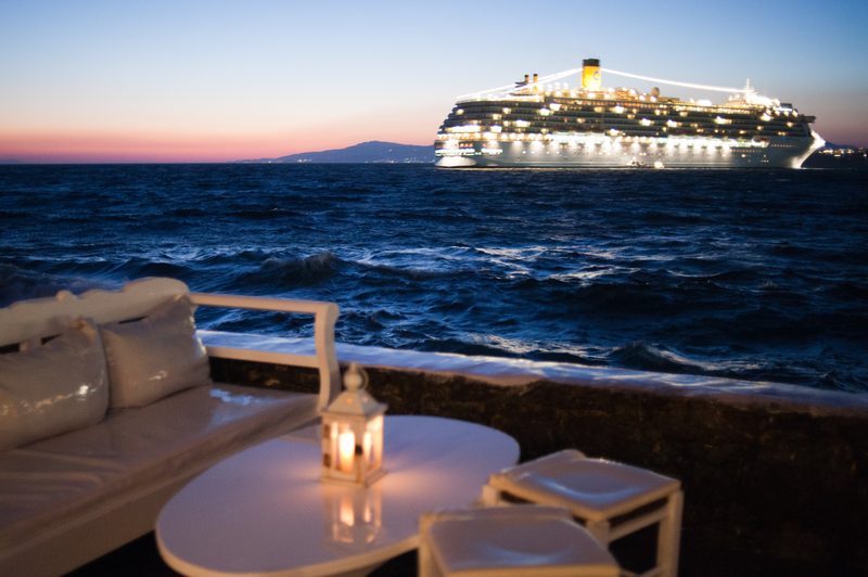 A cruise ship sailing along the coast of Mykonos Island in the Aegean Sea.