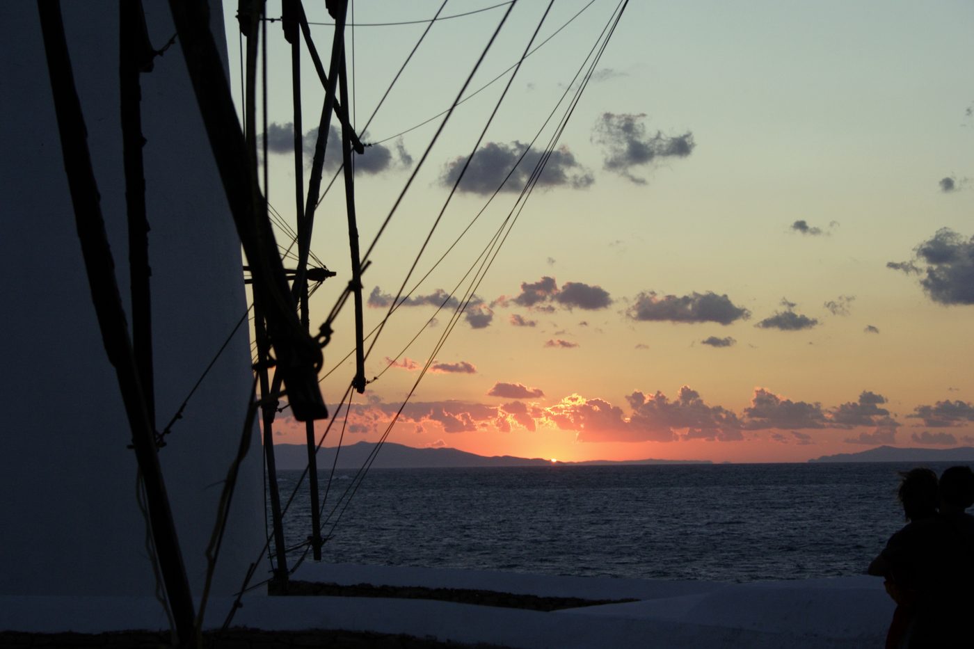 Sunset over the windmills of Mykonos with the sea beyond