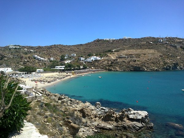 The sandy bay of Super Paradise Beach on Mykonos with turquoise water and surrounding hills